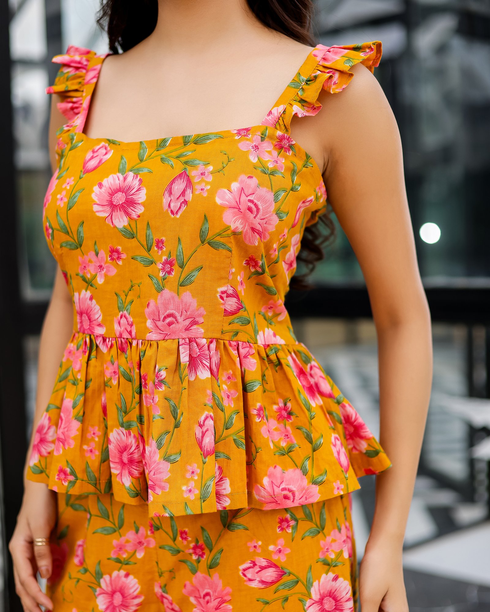 Peplum top close-up of Bolbo Sunshine Bloom coord set with ruffled shoulder straps and floral pattern details.